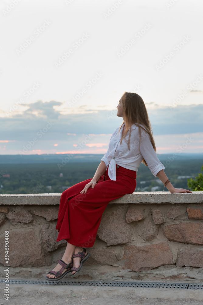 Beautiful girl is resting with view of nature. Vertical frame