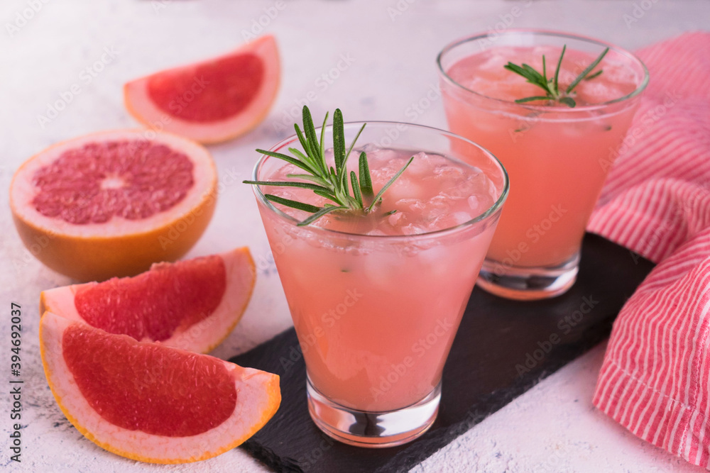 Two glasses with grapefruit juice and ice.
Close-up. Two glasses with grapefruit juice and ice.
Close-up.