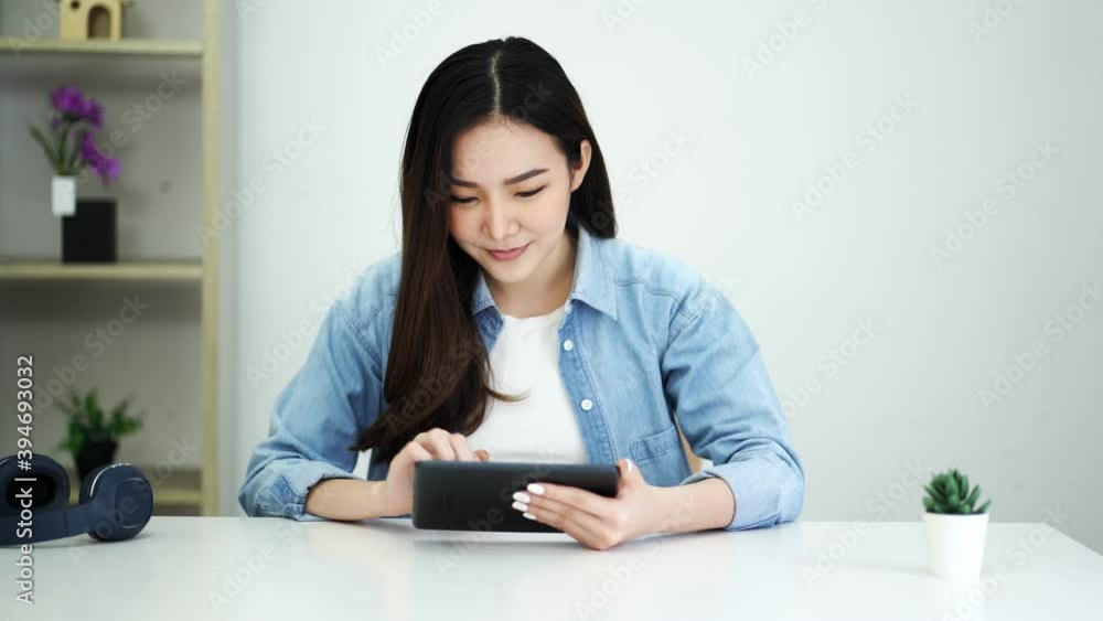 Happy young attractive asian woman using smartphone looking social media entertainment at home. Happy young attractive asian woman using smartphone looking social media entertainment at home.