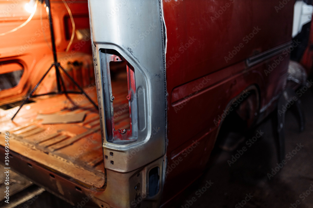 Fototapeta premium body repair of a red truck, welding of car body elements.