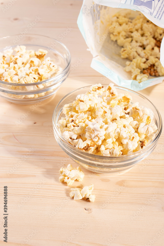 crispy golden ready to eat popcorn in a glass bowl. close up shot. crispy golden ready to eat popcorn in a glass bowl. close up shot.