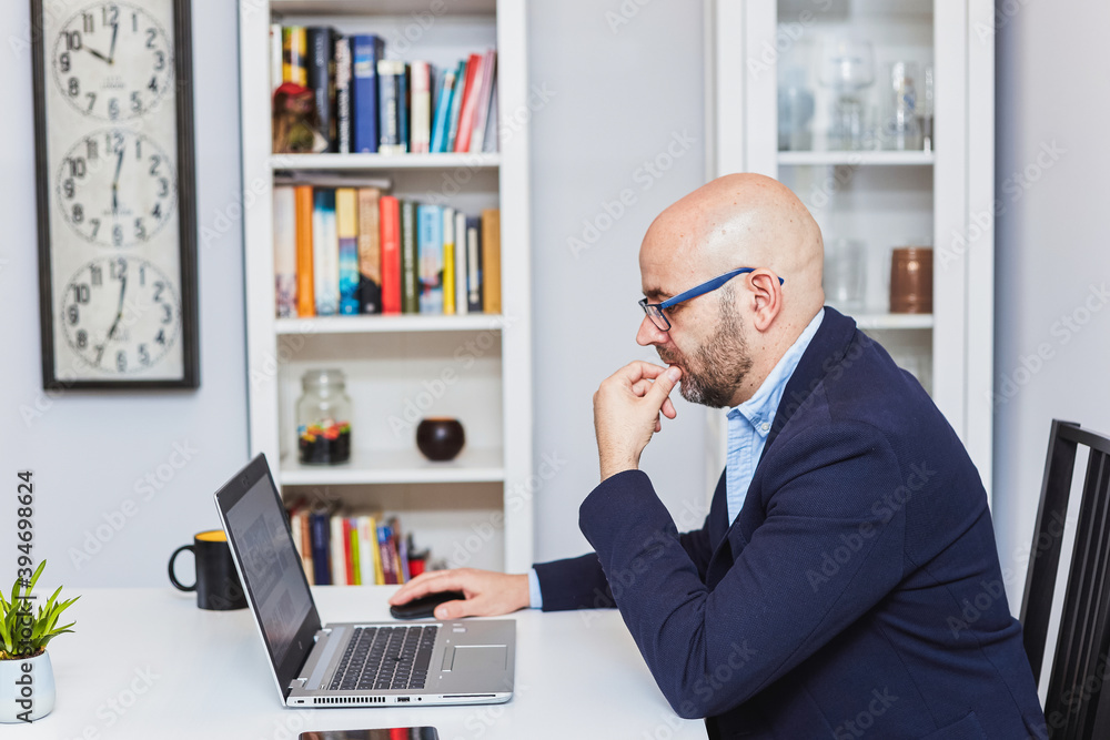 A self-employed businessman working from home with a laptop A self-employed businessman working from home with a laptop