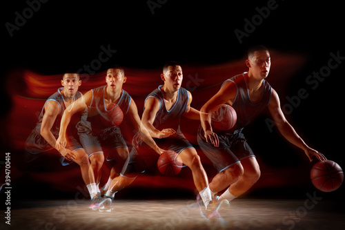 On the run. Young east asian basketball player in action and motion jumping in mixed strobe light over dark studio background. Concept of sport, movement, energy and dynamic, healthy lifestyle.