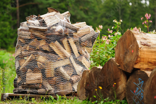 Fotografie Firewood in a mesh bag - Brennholz im Netzsack auf Palette