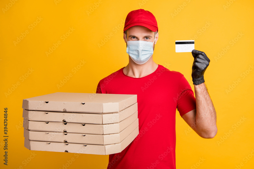 Photo of courier man hold pizza boxes debit card wear red t-shirt headwear gloves isolated yellow color background Photo of courier man hold pizza boxes debit card wear red t-shirt headwear gloves isolated yellow color background