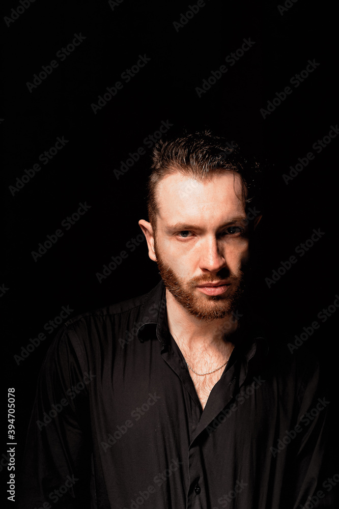 A man on a black background .Aggressive facial expression. Criminal personality A man on a black background .Aggressive facial expression. Criminal personality