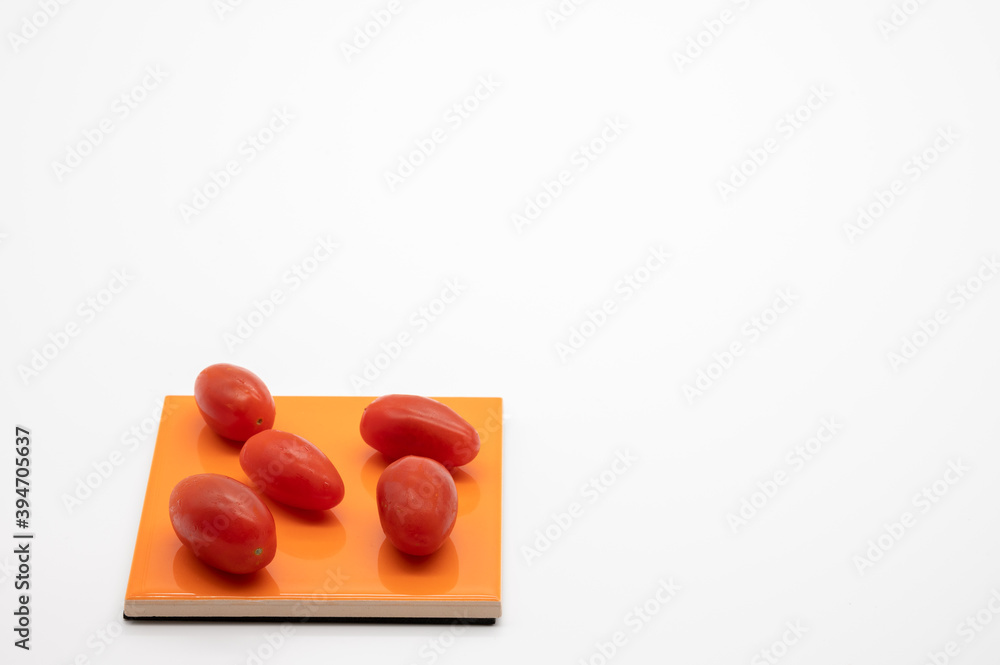 tomatoes on colored coasters and white background tomatoes on colored coasters and white background