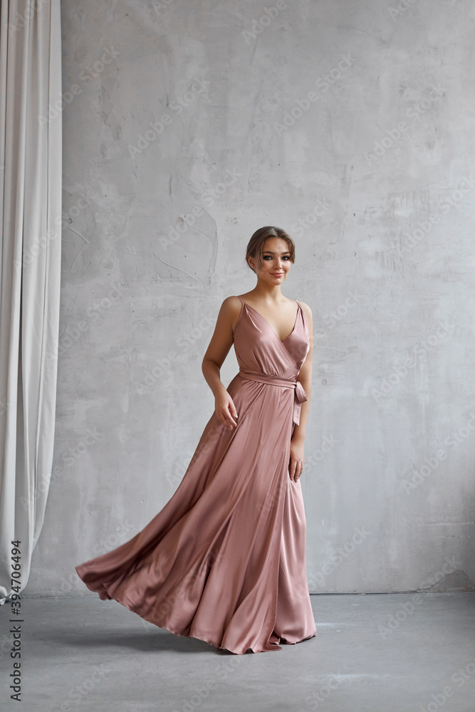 Beautiful sexy woman in a light beige silk dress. Noise, out of focus Beautiful sexy woman in a light beige silk dress. Noise, out of focus