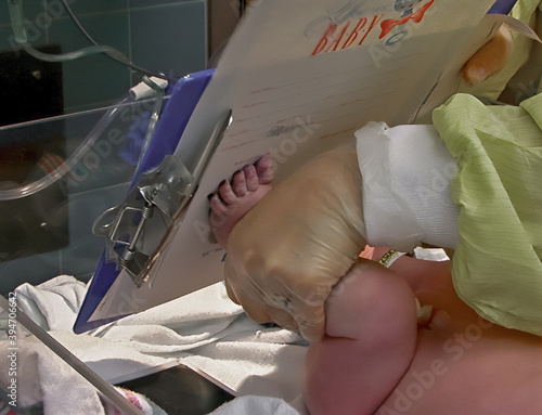 Fotografie Newborn baby footprint on birth identification hospital certificate - Close up