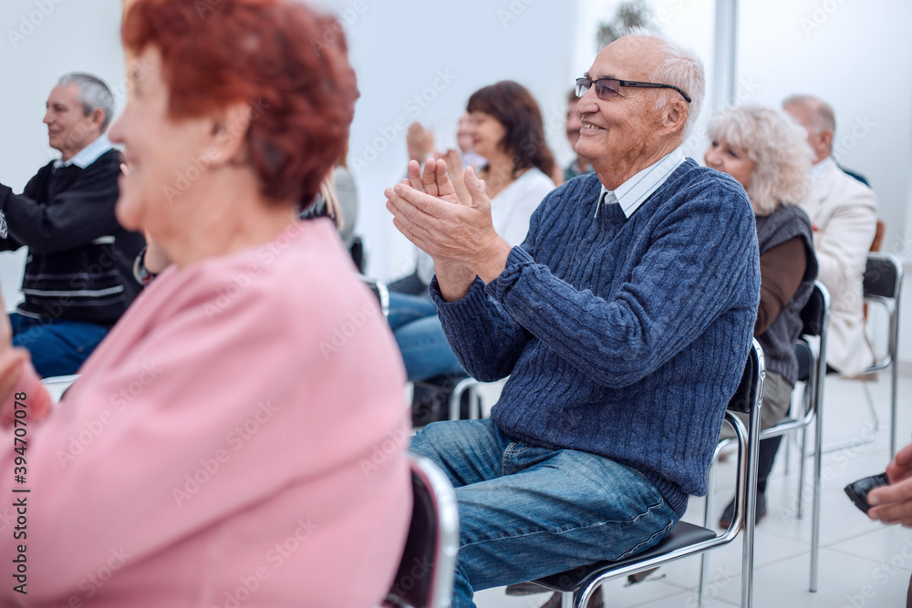 © ASDF - a group of senior citizens applaud in the conference room