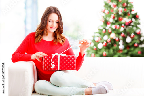 Fotografija Happy woman unwrapping christmas gift box at christmas time
