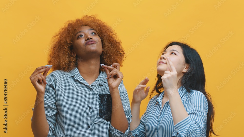 Two young crazy women dancing. isolated on yellow background. High quality photo Two young crazy women dancing. isolated on yellow background. High quality photo