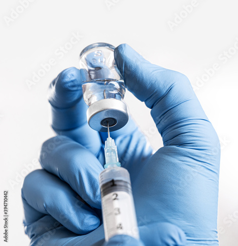 Doctor man holding a syringe with Coronavirus vaccine in his hands. Covid-19 Vaccination