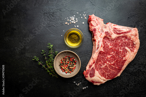 Tableau sur toile Raw fresh meat T-bone beef Steak on black background, top view