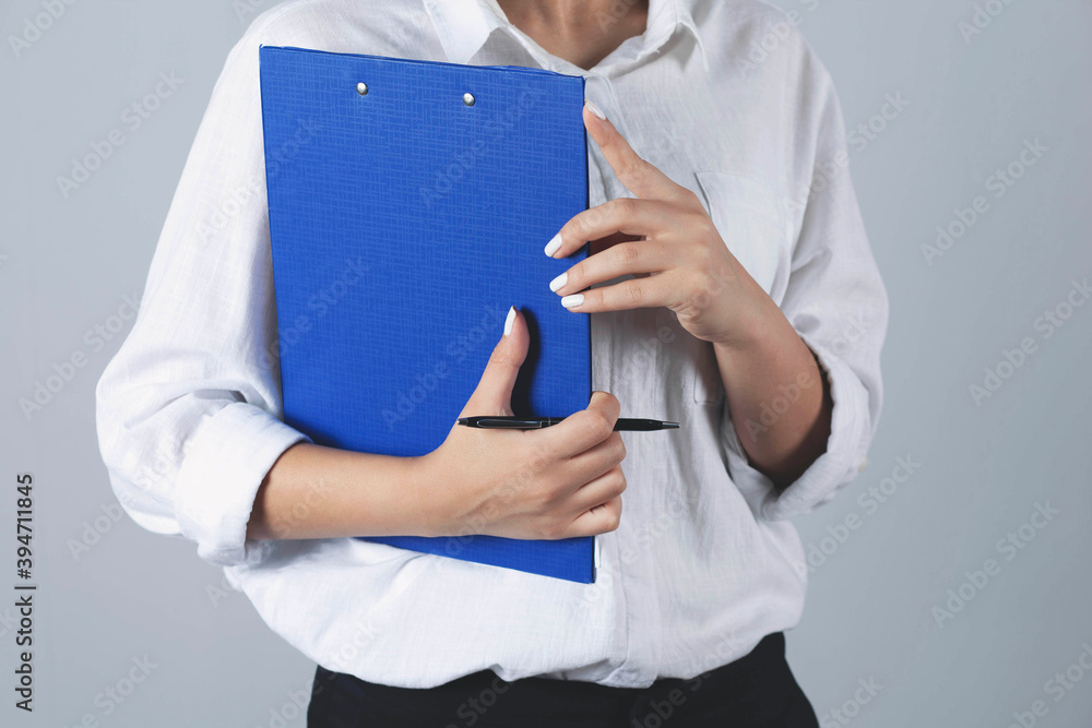 business Woman holds a blue folder. business Woman holds a blue folder.