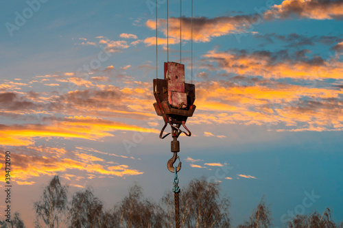Crane hook hanging on the beautiful sunset