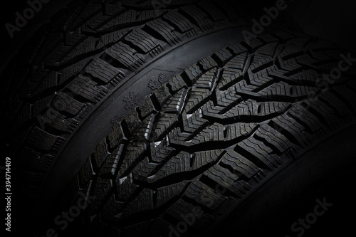 Closeup car tire isolated on black background. Wet with drops wheel against black © Angelov