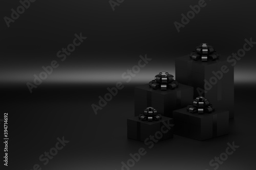 Four presents in boxes with glossy bows on black background. Image with blank copy space © dariaren