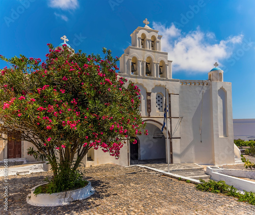 A panorama view across a courtyard towards the Virgin Mary church in Pyrgos, Santorini in summertime