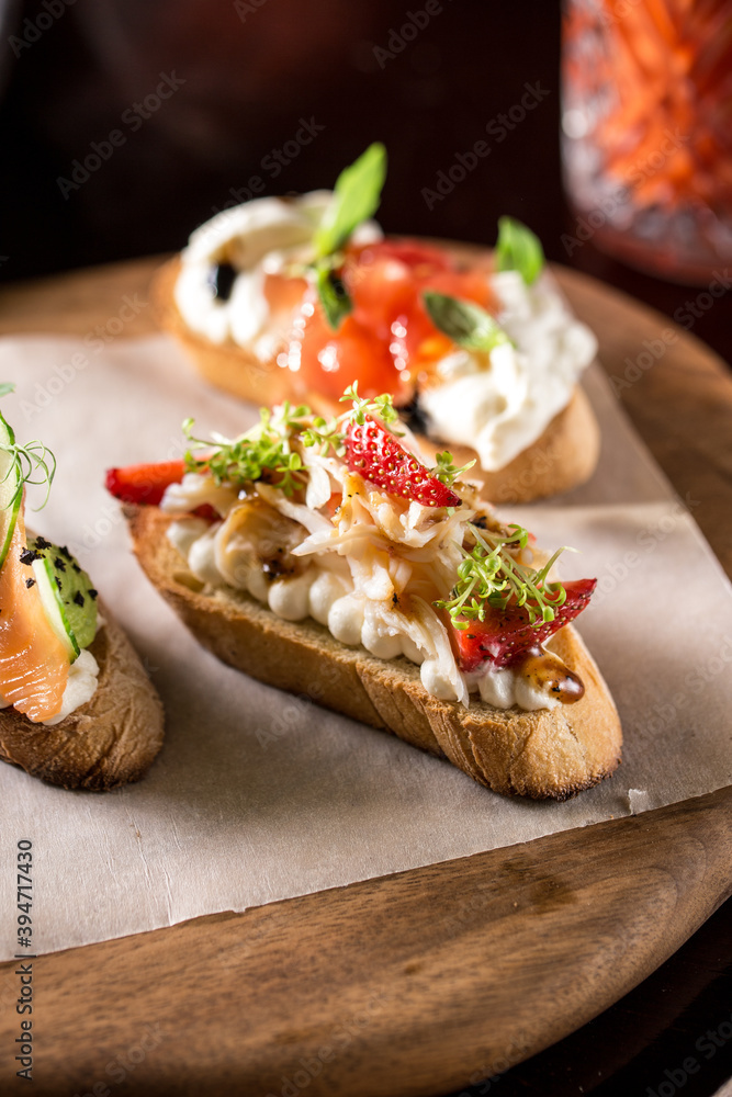 Brushetta bread sandwich snack authentic traditional spanish tapas on wooden plate at the restaurant