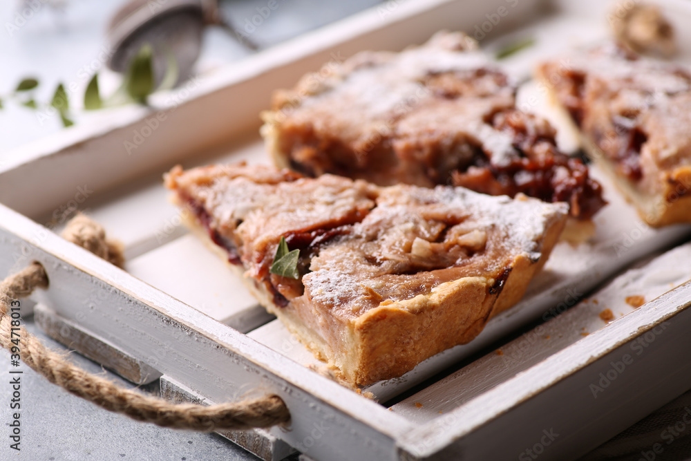 Bakery products. Plum tart with yogurt and cream. Shortbread dough with fruit filling on a white wooden tray on a light gray background with powdered sugar. Background image, copy space Bakery products. Plum tart with yogurt and cream. Shortbread dough with fruit filling on a white wooden tray on a light gray background with powdered sugar. Background image, copy space