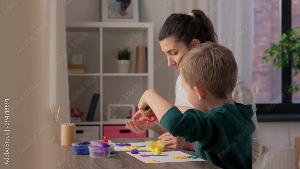 family, creativity and craft concept - mother and little son making picture of modeling clay at home family, creativity and craft concept - mother and little son making picture of modeling clay at home