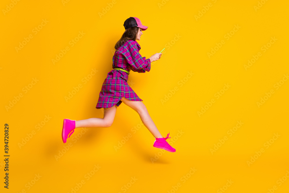 Full size profile photo of beautiful model jump type sms style magenta plaid outfit isolated on yellow color background