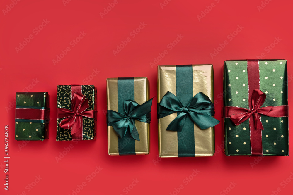 Fototapeta premium Christmas background with gift boxes with satin ribbons on red background. Trendy design in color of 2021. Top view.