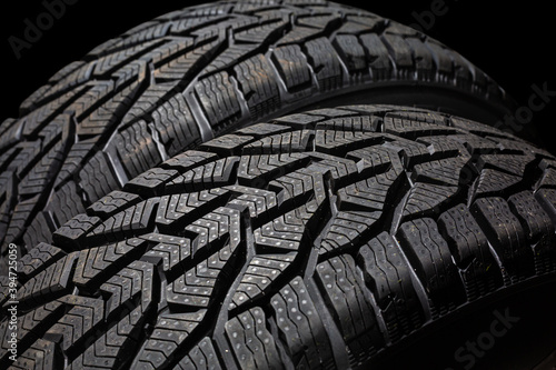 Closeup car tire isolated on black background. Wet with drops wheel against black