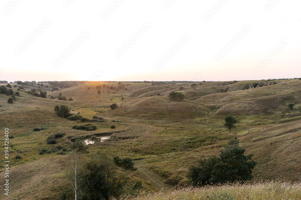 Hilly countryside at sunset in summer. Picturesque nature of countryside