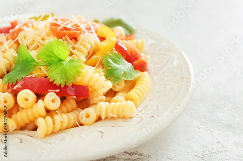 Plate with tasty pasta primavera on light background