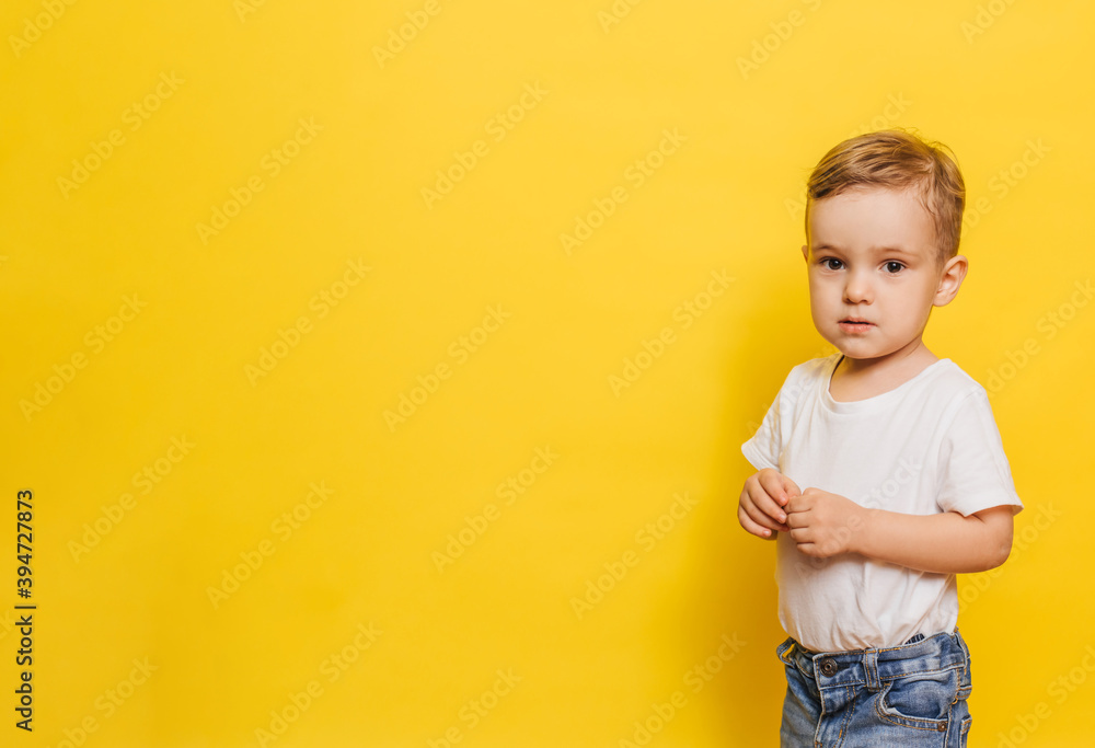 Portrait of a cute laughing little boy on a yellow background. Copy space. Portrait of a cute laughing little boy on a yellow background. Copy space.