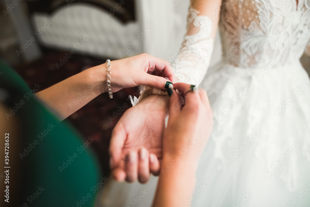 Hands of bridesmaids on bridal dress. Happy marriage and bride at wedding day concept