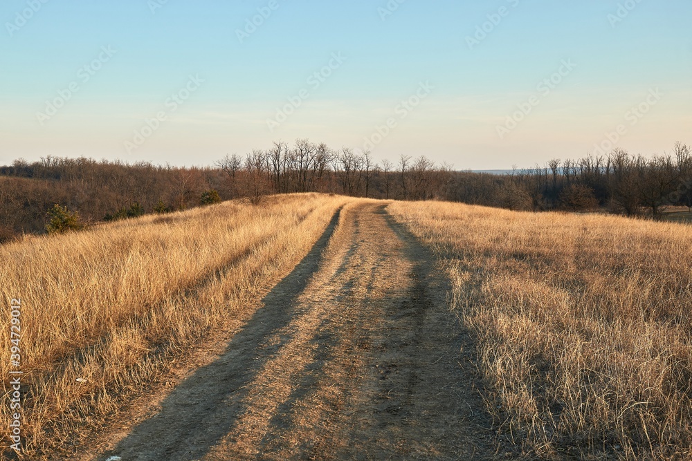 Dirt road in a countryside field in dry late autumn Dirt road in a countryside field in dry late autumn