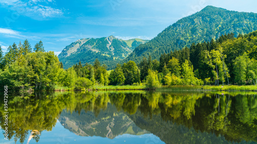 Germany, Allgaeu, Impressive nebelhorn alps mountains and forest reflecting in silent water of moorweiher lake in oberstdorf photo