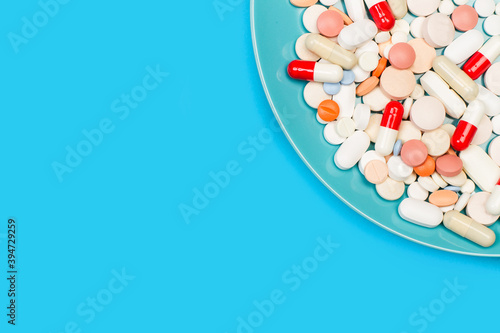 Farmacos, pastillas y medicamentos sobre un fondo celeste brillante liso y aislado. Vista superior. Copy space