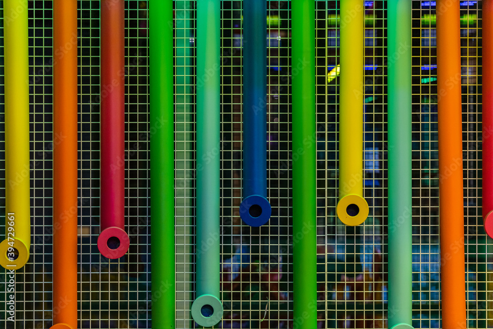Colorful plastic pipes hanged on metal net Colorful plastic pipes hanged on metal net