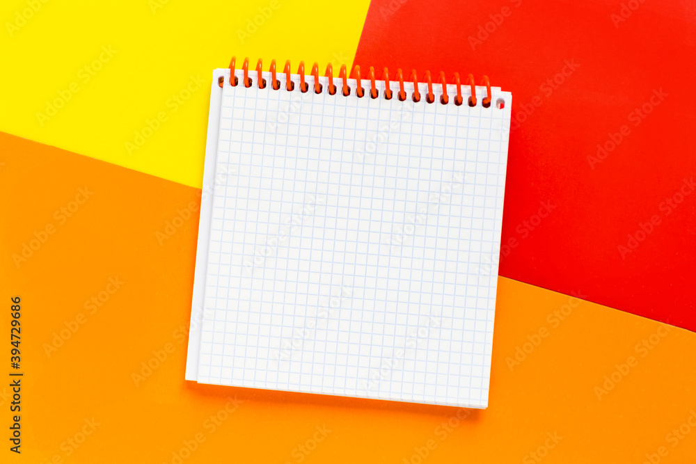 Open blank notepad on bright colored yellow, red, orange backgrounds. Template with copy space for your text Open blank notepad on bright colored yellow, red, orange backgrounds. Template with copy space for your text