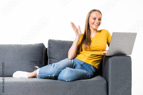 Excited young woman in casual clothes sitting on couch spending time isolated on white background . 