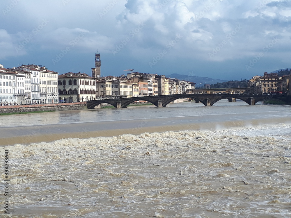 Italian city with river, clouds, buildings, bridge