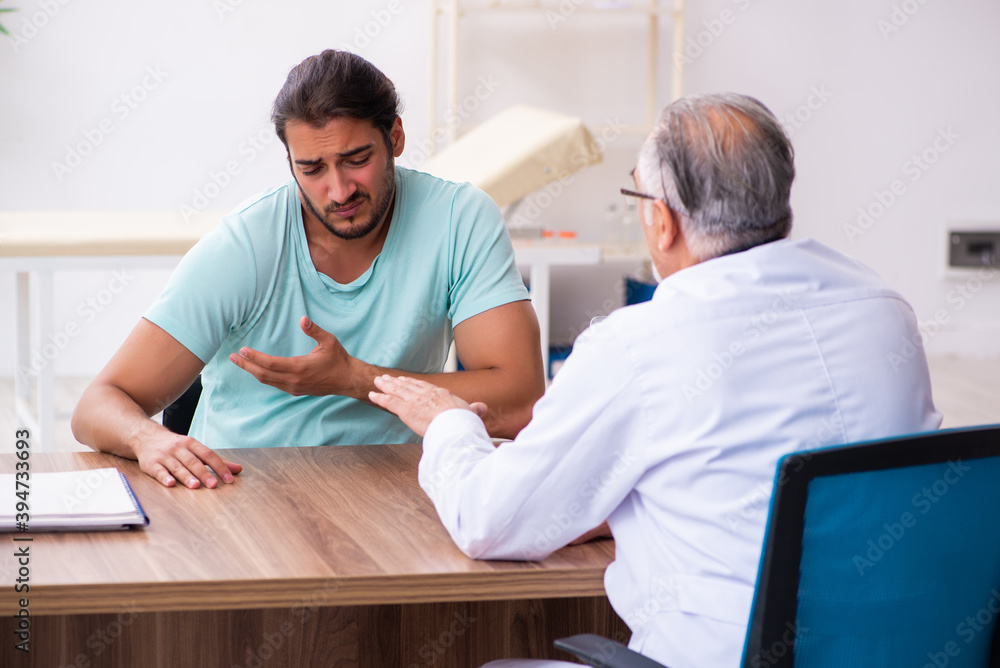 Injured young man visiting old doctor Injured young man visiting old doctor
