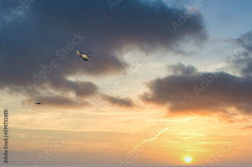 The helicopter soars against the background of the evening cloudy sky