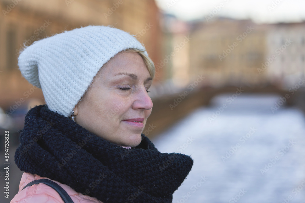 Portrait of a middle aged woman with closed eyes in a scarf and hat Portrait of a middle aged woman with closed eyes in a scarf and hat