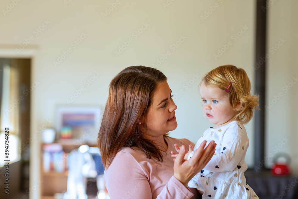 young mum holding toddler and talking to her young mum holding toddler and talking to her
