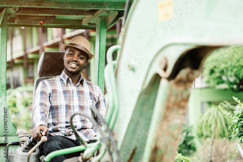 African worker driving heavy construction equipment backhoe with smile and happy © arrowsmith2