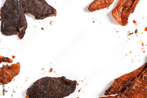 Chicken and beef jerky with spices on a white background top view. Free space for text. Tasty spicy jerky, homemade beer snack.