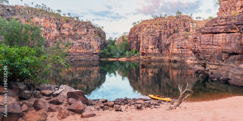 Sunset light over rocky cliff and still pool of outback Nitmiluk Gorge photo