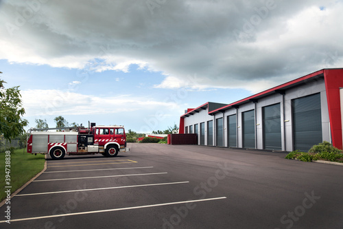 Single fire truck parked outside large modern shed photo