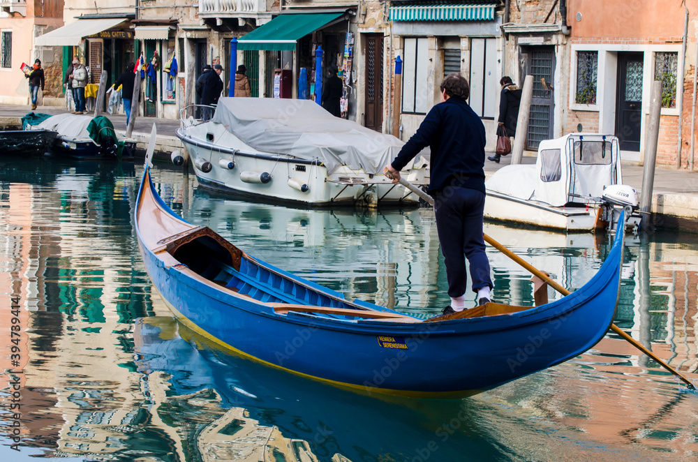 Gondoliere naviga in un canale di Venezia