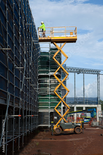 Construction worker on a scissor lift on an industrial building site